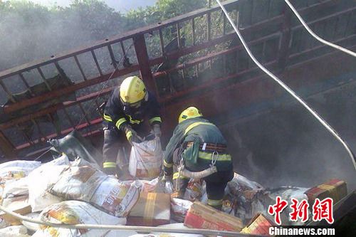 8月1日6時(shí)左右，滬昆高速上饒段一貨車側(cè)翻著火，駕駛室燒成空殼。圖為消防官兵清理現(xiàn)場。吳兵章 攝